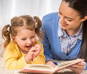 Kindersprache - Mutter schaut mit ihrer Tochter ein Bilderbuch an - Besonders das gemeinsame Ansehen von Bilderbüchern eignet sich hervorragend um Sprache gezielt und richtig zu fördern