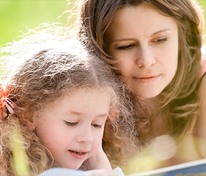 Mutter liest mit ihrer Tochter in einem Buch
